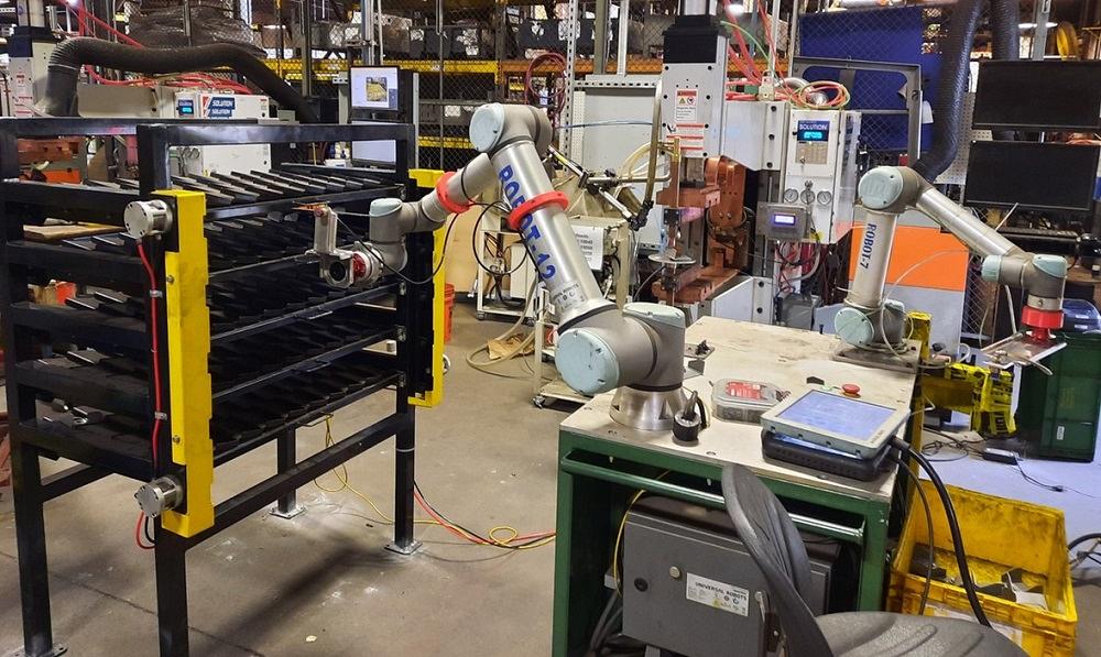 Robot arms tending machines in a metal processing workshop