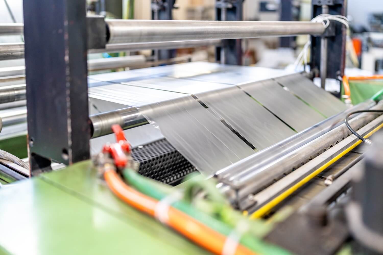 Plastic film running through the rollers of a packaging line